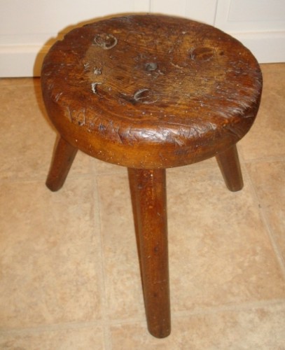 An old, well-used milking stool. Via WikiMedia Commons.
