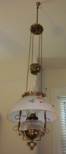 Early/mid 19th century height adjustable pendant oil lamp. Brass fixtures, painted glass shade. Chain and counterweight allow it to raised and lowered. Now used as paraffin lamp; originally probably intended to be fueled with whale oil.via Wikipedia, CC License.